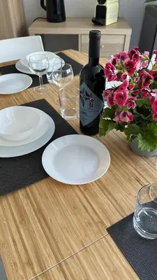 a table with plates and a bottle of wine and flowers at Appia Suite in Rome