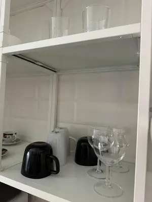 a shelf with glasses and a wine glass on it at Appia Suite in Rome