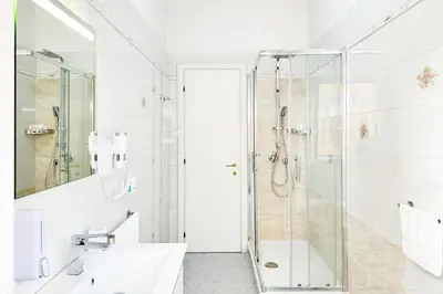 a white bathroom with a shower and a sink at Roma Passion Suite in Rome