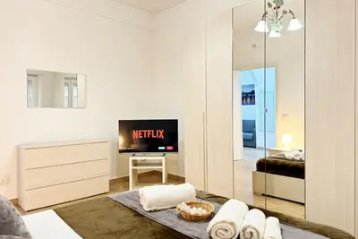 a living room with a bed and a tv and a mirror at Roma Passion Suite in Rome
