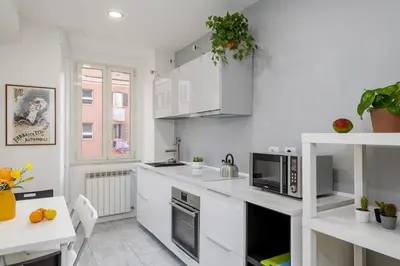 a kitchen with white cabinets and a counter top at Domus Aurea3 flat a stone's throw from Colosseum in Rome