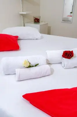 two beds with red and white towels and roses on them at Domus Aurea3 flat a stone's throw from Colosseum in Rome