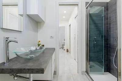 a bathroom with a glass bowl sink and a shower at Domus Aurea3 flat a stone's throw from Colosseum in Rome