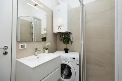 a small bathroom with a sink and a washing machine at Domus Aurea a stone's throw from the Colosseum in Rome