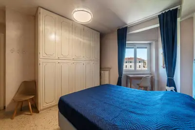 a bedroom with a blue bed and a window at GuestHost - La Rosa di Trastevere in Rome