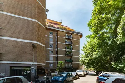 a tall building with cars parked in a parking lot at GuestHost - La Rosa di Trastevere in Rome