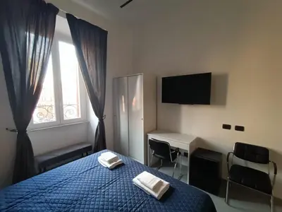 a bedroom with a bed and a desk and a television at World Wide Bed Termini in Rome