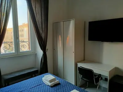 a bedroom with a bed and a desk and a window at World Wide Bed Termini in Rome
