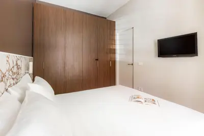 a bedroom with a white bed with a tv on it at Interno2 - Cozy flat near Vatican Museums in Rome