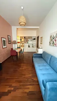 a living room with a blue couch and a table at Borgo Una Casa Nel Vicolo in Rome
