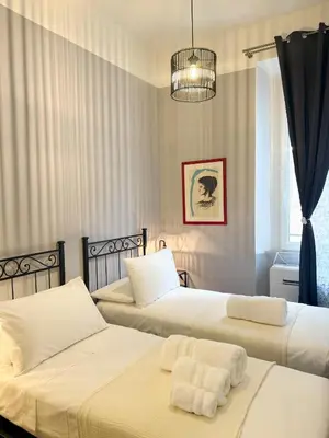 a bedroom with two beds with white sheets at Borgo Una Casa Nel Vicolo in Rome