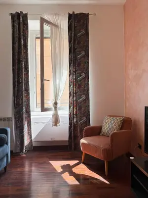 a living room with a chair and a window at Borgo Una Casa Nel Vicolo in Rome