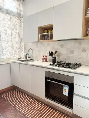 a kitchen with white cabinets and a sink and an oven at Borgo Una Casa Nel Vicolo in Rome