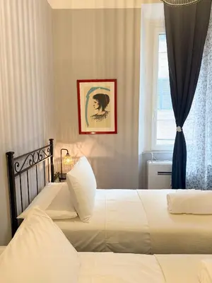 a bedroom with two beds and a window at Borgo Una Casa Nel Vicolo in Rome