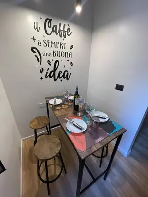 a table with two chairs and a sign on a wall at Basilica San Giovanni Appia Antica At a Friends House in Rome
