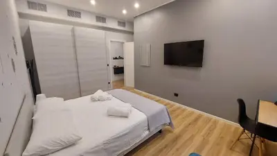 a bedroom with a white bed and a flat screen tv at Basilica San Giovanni Appia Antica At a Friends House in Rome