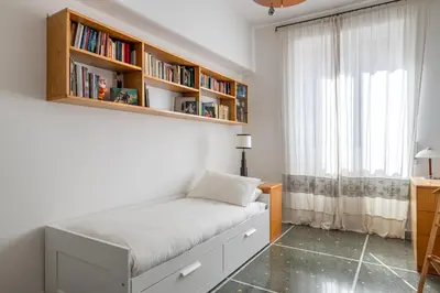 a bedroom with a bed with a book shelf at Bright and spacious flat in the hearth of Rome in Rome