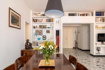 a dining room with a vase of flowers on a table at Bright and spacious flat in the hearth of Rome in Rome