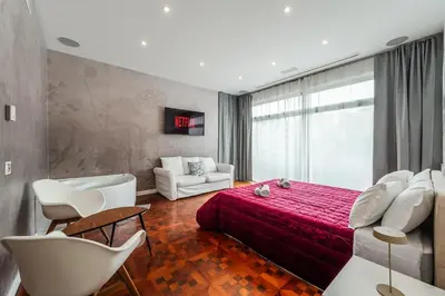 a bedroom with a red bed and a couch at Rome Centre - Spacious Apartment - Jacuzzi - AC - WiFi in Rome