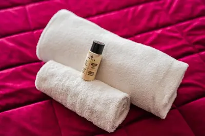 a white towel with a bottle of moisturizing moisturizers on it at Rome Centre - Spacious Apartment - Jacuzzi - AC - WiFi in Rome