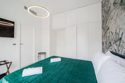 a bedroom with a green bed with two towels at Rome Centre - Spacious Apartment - AC - Wi-Fi - Metro in Rome