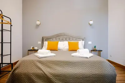 a bedroom with a large bed with yellow and white pillows at Suite Vaticano in Rome
