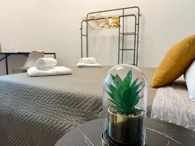a plant in a glass jar on a table next to a bed at Suite Vaticano in Rome