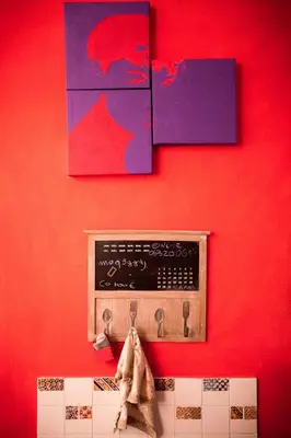a red wall with a radio and some paintings at Casetta Ponte Milvio in Rome
