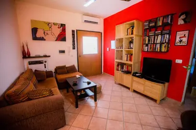 a living room with red walls and a flat screen tv at Casetta Ponte Milvio in Rome