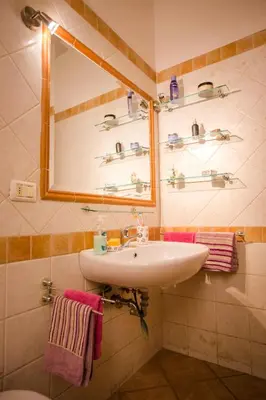 a bathroom with a sink and a mirror and towels at Casetta Ponte Milvio in Rome