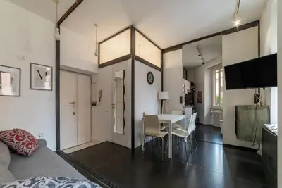 a room with a bed and a table and chairs at GuestHost - Cozy Apartment near Tiburtina in Rome