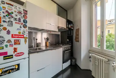 a kitchen with a refrigerator with magnets on it at GuestHost - Cozy Apartment near Tiburtina in Rome