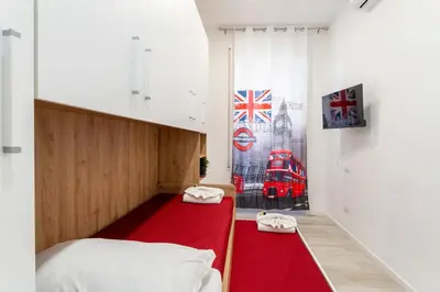 a bedroom with two beds and a red rug at Jhonny's Apartment Near Vatican 3 bedroom's in Rome