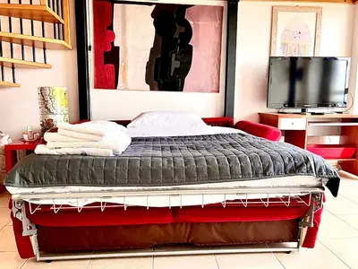a wooden staircase in a living room with a red table at Loft Pantanella Porta Magiore in Rome