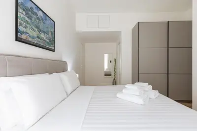 a bedroom with a white bed with towels on it at Hostly-The Montebello Suite-Near Trevi in Rome
