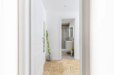 a hallway with white walls and a wooden floor at Hostly-The Montebello Suite-Near Trevi in Rome
