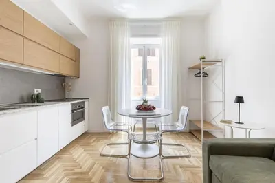 a kitchen with a table and chairs in a room at Hostly-The Montebello Suite-Near Trevi in Rome