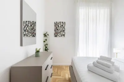 a white bedroom with a bed and a desk at Hostly-The Montebello Suite-Near Trevi in Rome
