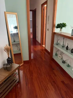 a living room with a wooden floor and a mirror at San Pietro Street 9 in Rome
