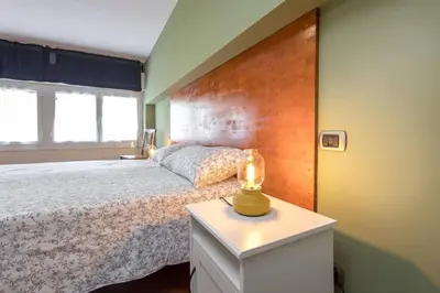 a bedroom with a large white bed with two lamps at Green Home Caravaggio in Rome