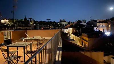 a balcony with a table and chairs on a roof at Rarity Suites in Rome