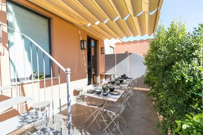 a patio with tables and chairs on a balcony at Rarity Suites in Rome