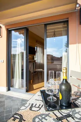 a table with two wine glasses and a bottle at Rarity Suites in Rome