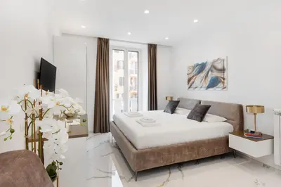 a white bedroom with a bed and a couch at Eternal House Caulonia in Rome