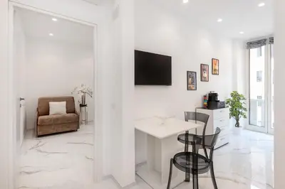 a white living room with a table and a chair at Eternal House Caulonia in Rome