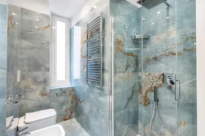 a bathroom with a toilet and a glass shower at Eternal House Caulonia in Rome