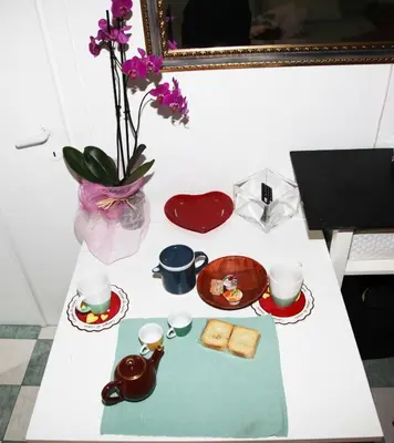 a table with a tray of food and cups and flowers at La casetta di Brigida in Rome