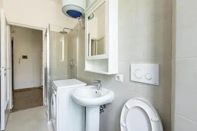 a white bathroom with a sink and a toilet at La Casa di Edo in Rome