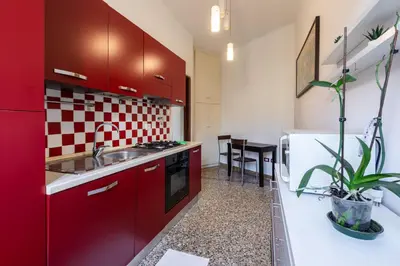 a kitchen with red cabinets and a sink at La Casa di Edo in Rome
