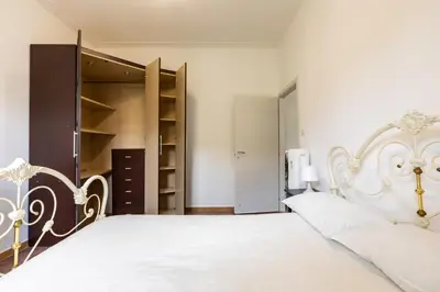 a bedroom with a white bed and a closet at La Casa di Edo in Rome
